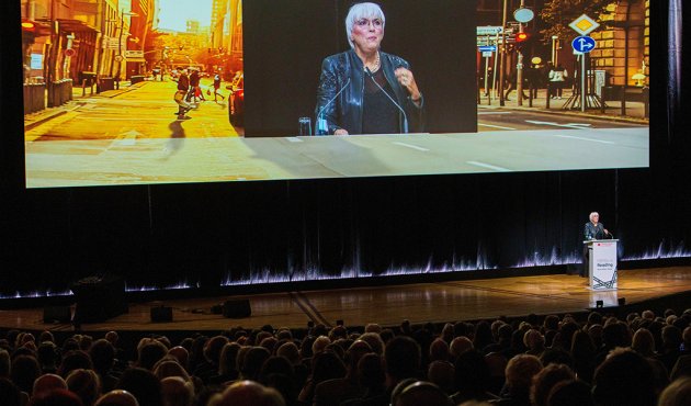 Kulturstaatsministerin Claudia Roth ist bei der Eröffnungsfeier der Frankfurter Buchmesse auf einem Bildschirm zu sehen